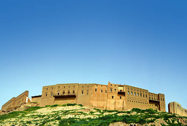 Erbil Citadel - UNESCO world heritage site Erbil / Hewler, Kurdistan, Iraq: brick walls of Erbil Citadel seen from the lower town - Qelay Hewlêr - UNESCO world heritage site - tell or occupied mound, occupied since the 5th millennium BC - blue sky, copy space - photo by M.Torres kurdistan stock pictures, royalty-free photos & images