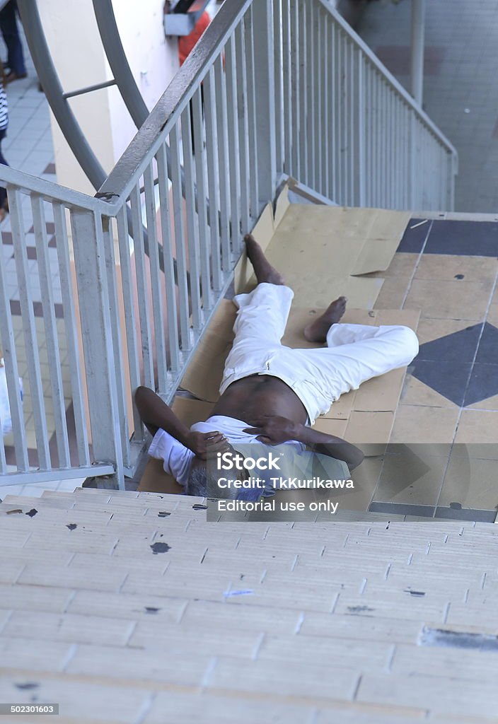 Homeless man in Kuala Lumpur Malaysia Kuala Lumpur Malaysia - 30 May, 2014: Homeless man sleeps on a stairway in Kuala Lumpur Malaysia. Adult Stock Photo