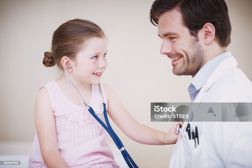 I've always wanted to know how this works! A little girl reverses roles with her doctor by using his stethoscope on him 30-39 Years Stock Photo