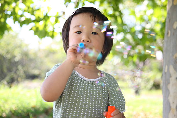 istock Japanese girl playing with soap bubbles 502303431