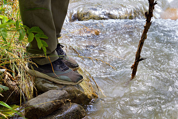 istock Tourist passes mountain river feet close-up 502313364