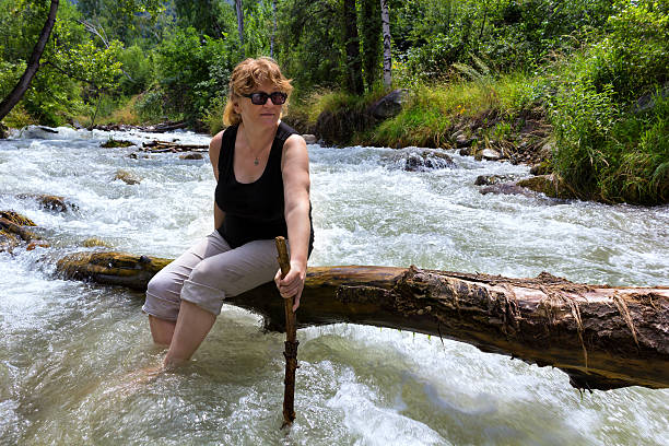 woman goes on a log mountain river