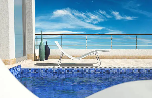 Two sunbeds are located by a villa pool