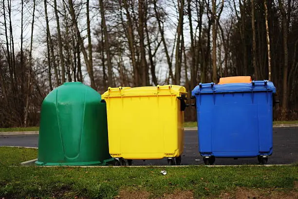 Yellow, green and blue bins in no urban space.