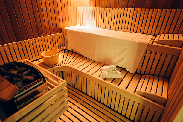 Wooden sauna room Empty wooden sauna room with towels, ladle, bucket ready to be used swedish sauna stock pictures, royalty-free photos & images