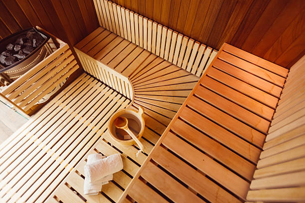 Wooden sauna room Interior of a wooden sauna room,with towels,bucket and ladle, view from the top swedish sauna stock pictures, royalty-free photos & images