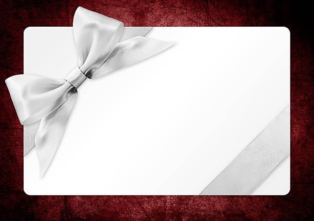 istock gift card with silver ribbon bow Isolated on red backgrou 502318654