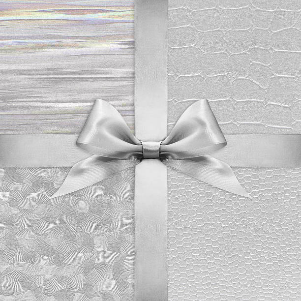 istock Shiny silver satin ribbon bow on argent background 502318854