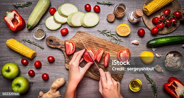 Photo libre de droit de Femme Mains Coupe Tomates Rustique Kitchen Table Menus Végétarien Concept banque d'images et plus d'images libres de droit de Légume