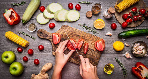 женщина руку с помидорами деревенский kitchen table, вегетарианские концепции. - vegetable cutter стоковые фото и изображения