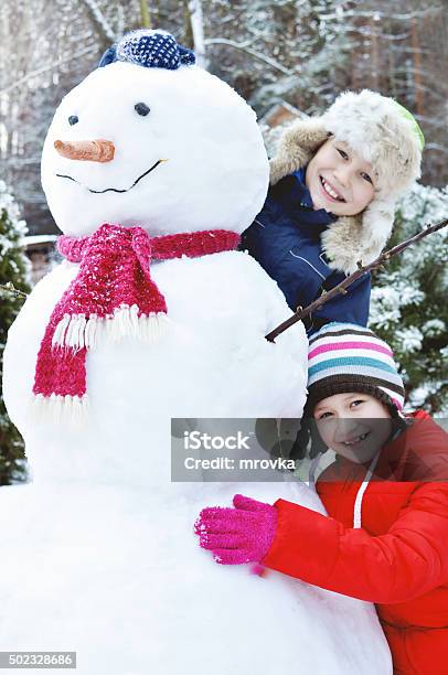 Happy Children Make A Snowman Stock Photo - Download Image Now - Child, Making a Snowman, 2015