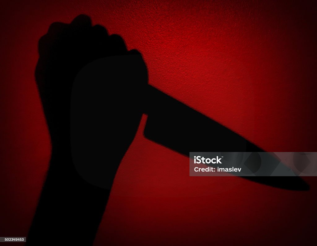 Psycho Murder Hand with a knife. Shadow of hand assassin. In Silhouette Stock Photo