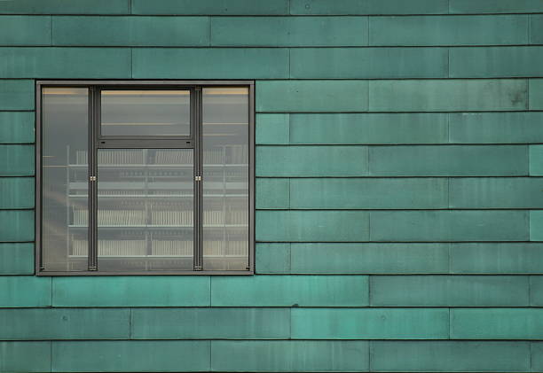 Rows of green metal panels and a window showing the inside of the library.