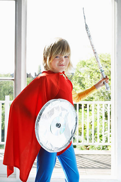 istock Boy In Superhero Costume With Toy Shield And Sword 502346375