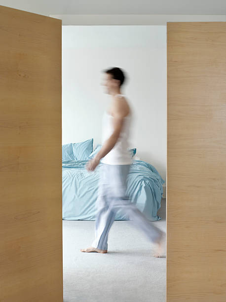 istock Side view of a blurred man walking in bedroom 502347219