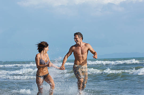 istock Couple Running In Surf At Beach 502348339