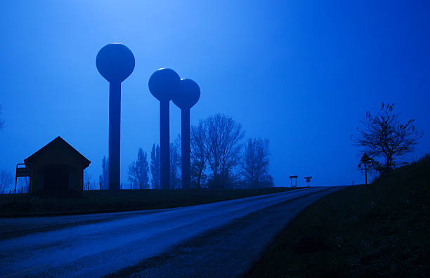 Community public water tower utility and road at moonlight