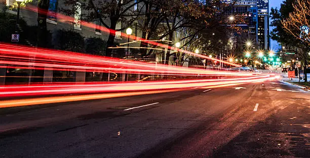 Fast moving vehicle in the city at night with office building, long exposure