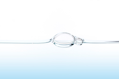 Perfectly flat water surface line with a large and small bubble.