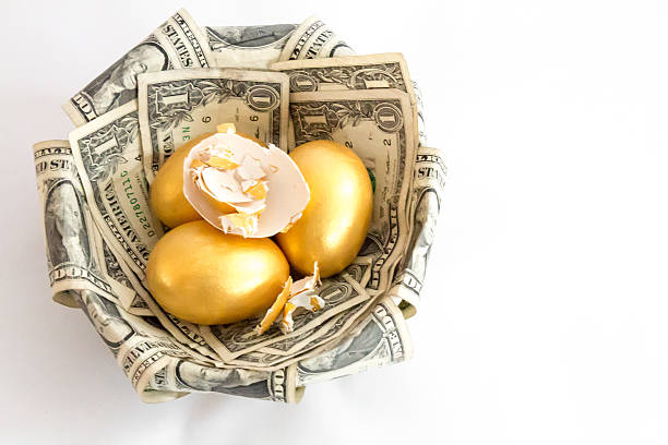 istock Golden eggs in a nest with one broken on top 502353298