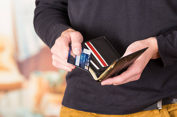 istock Man wearing beige jeans and dark sweater holding wallet open 502353796