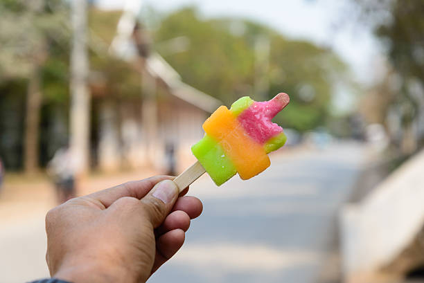 Bitten colorful popsicle in hand.