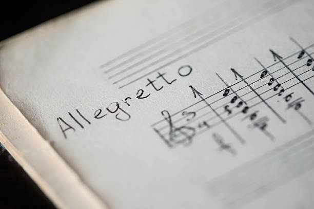 musical tempo "allegretto" em um livro de música com notas escrito à mão - allegretto - fotografias e filmes do acervo