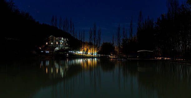 istock Reflected house in a lake at night in the mountains 502360020