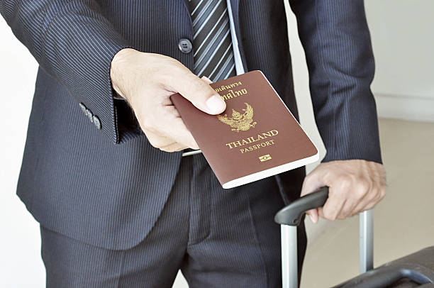 geschäftsmann hand geben passport - customs official examining emigration and immigration document stock-fotos und bilder