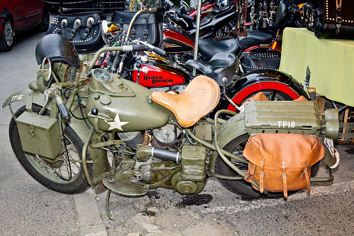 Łagów, Poland - July 12, 2014: Row of Harley Davidson motorcycles are standing on the sidewalk next to a street stall with the motorcycle items  during Motorcycle Rally in Łagów, Poland. Harley Davidson is an American motorcycle manufacturer. Founded in Milwaukee, Wisconsin, during the first decade of the 20th century.