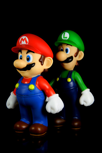 Vancouver, Canada - October 4, 2012: Luigi and Mario from the Nintendo Super Mario franchise of games, posed against a black background. The toys are from Banpresto Company.