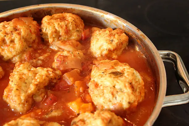 Photo of Image of homemade chicken casserole in saucepan, with dumplings floating