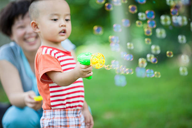 istock Mother accompanied child blowing bubbles outdoors 502377869