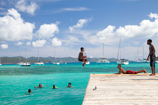 Jost Van Dyke, British Virgin Islands - July 14, 2014: local kids from Jost Van Dyke jumping for fun from the dock