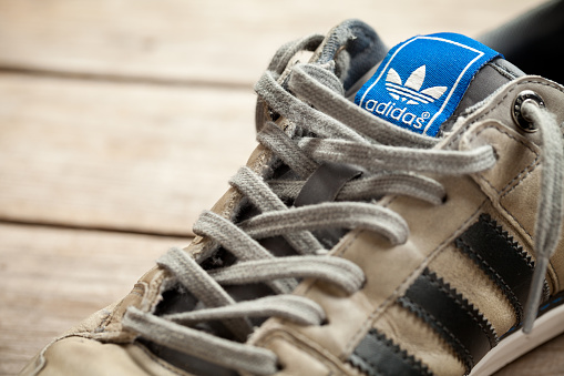 Jasien, Poland - June 13, 2014: Adidas shoes on old wood floor. Adidas AG is a German sports apparel manufacturer and parent company of the Adidas Group.