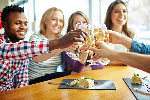 Young people toasting with champagne in restaurant