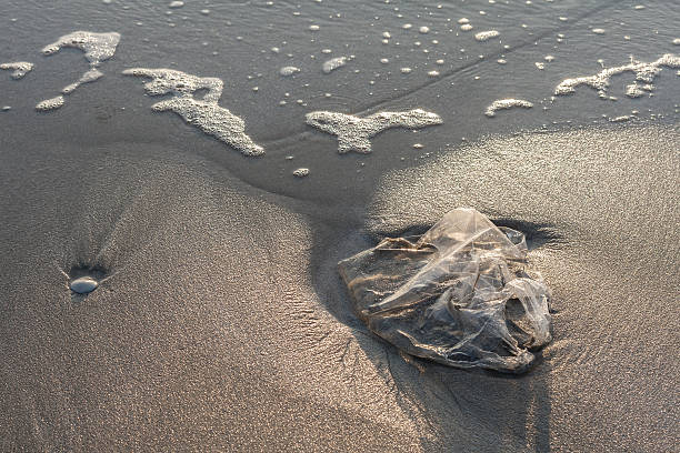 Used plastic bag garbage on sand beach stock photo