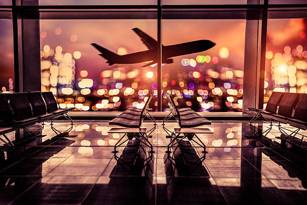 Airport Lounge and airplane take off in the city Empty airport lounge shot at night in front of the city skyline with airplane taking off against the bright lit of the city. exclusive travel stock pictures, royalty-free photos & images