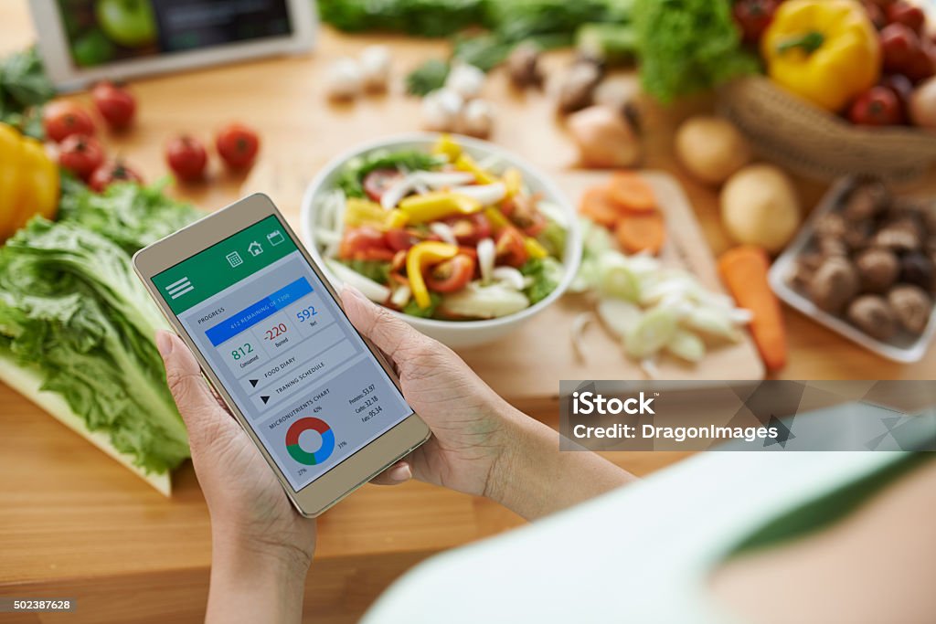 Calorie counter Woman using calorie counter application on her smartphone Dieting Stock Photo