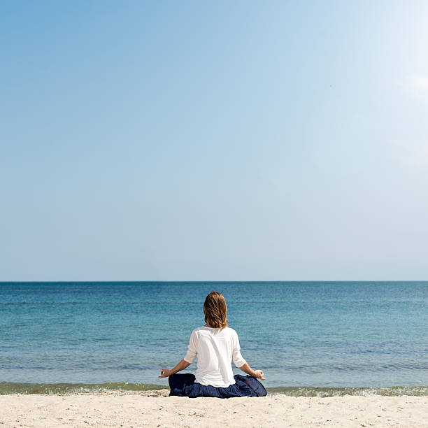 istock Woman meditating at the sea 502390846