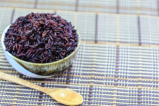 istock Brown rice in bowl with wooden spoon. 502392862