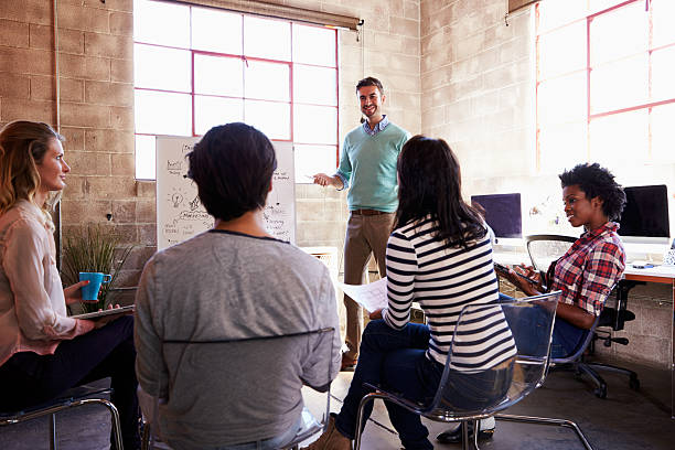 Group Of Designers Having Brainstorming Session In Office