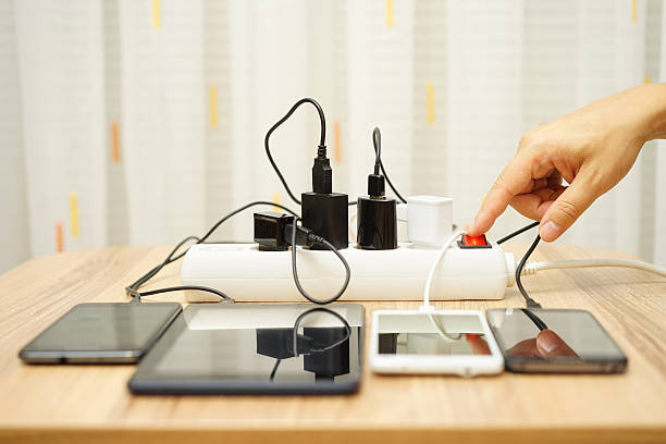 mann ausschaltet power adapter für mobiltelefone - stromstecker fotos stock-fotos und bilder