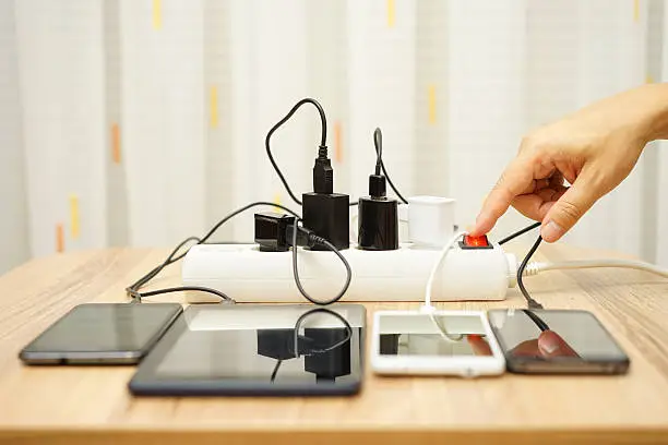 Photo of man is turning off  power adapters for mobile phones