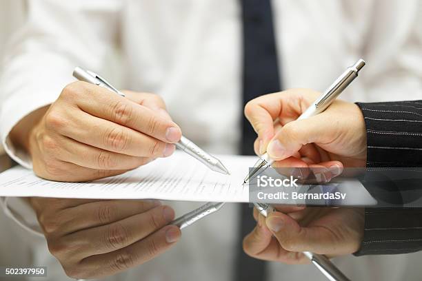 Business Man Is Pointing Woman Where To Sign Document Stock Photo - Download Image Now