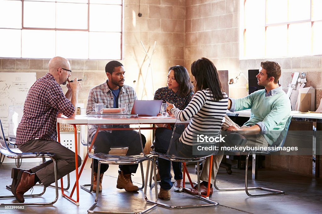 Group Of Designers Having Meeting Around Table In Office Modern Stock Photo