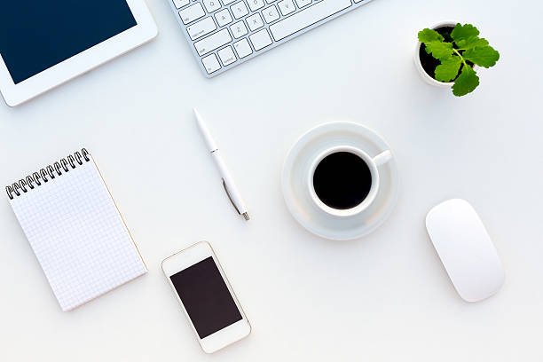 istock Top View of White Office Desk Modern Electronics Stationery Flower 502411046