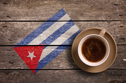 Cuba flag with coffee on table. top view