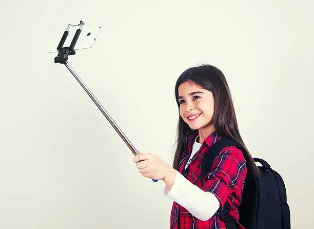 Photo of pretty school girl doing selfie