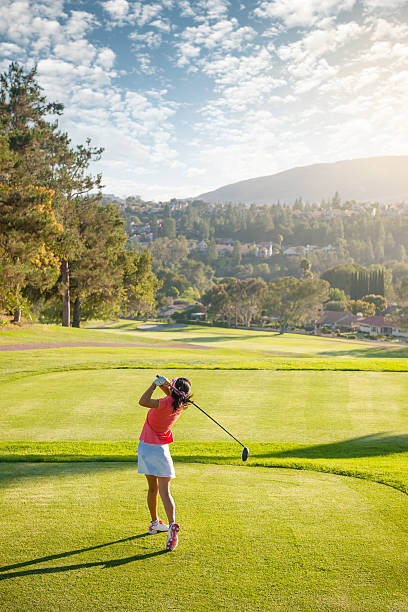 Golf Swing A women swinging at the golf ball on a beautiful course. http://blog.michaelsvoboda.com/GolfBanner.jpg swinger photo stock pictures, royalty-free photos & images